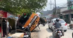 Truk bermuatan gypsum terguling di Jalan Kali Abang Tengah, Kota Bekasi, dan menimpa dua warung di sebelahnya pada Senin, 23 Juni 2025. (Sumber: POSKOTA | Foto: Nurpini Aulia Rapika)