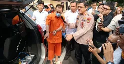 Tersangka kasus illegal access dengan modus SMS palsu menunjukkan alat yang digunakan untuk kejahatan phising di Mapolda Metro Jaya, Selasa, 24 Juni 2025. (Sumber: POSKOTA | Foto: Ali Mansur)