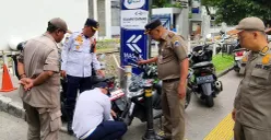 Sebanyak 80 ban sepeda motor yang parkir di trotoar Jalan Kyai Tapa, Gropet, Jakbar, digembosi petugas, Selasa, 24 Juni 2025. (Sumber: POSKOTA | Foto: Dishub Jakarta)