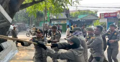 Satuan Polisi Pamong Praja (Satpol PP) Kota Depok menertibkan pedagang kaki lima liat mendiringan bangunan permanen atau tidak di sepanjang Jalan Pitara - Cipayung, Kota Depok. (Sumber: Poskota/Angga Pahlevi)