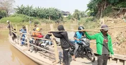 Fadil, 32 tahun, warga gabus pabrik, bersama teman-temannya sedang mengoperasikan perahu eretan untuk menyebrangi kali Bekasi yang menghubungkan daerah Tambun Utara dan Babelan. (Sumber: Poskota/Nurpini Aulia Rapika)