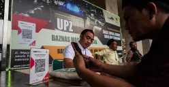 Petugas melayani sejumlah jamaah saat proses pembayaran zakat fitrah di Masjid Istiqlal, Jakarta. (Sumber: Poskota/Bilal Nugraha Ginanjar)