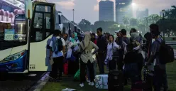 Sejumlah pemudik bersiap menaiki bus dalam program Mudik Gratis saat senja. Dengan membawa barang bawaan, mereka tampak bersemangat untuk pulang ke kampung halaman. (Sumber: Poskota/Bilal Nugraha Ginanjar)
