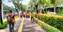 Petugas kebersihan Dinas Lingkungan Hidup (DLH) DKI Jakarta saat membersihkan sampah masa buruh di depan Balai Kota DKI Jakarta. (Sumber: Poskota/M. Tegar Jihad)