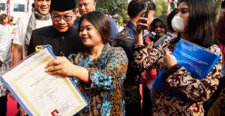 Warga menerima ijazah dari program pemutihan ijazah di Balai Kota Jakarta, Jum'at, 2 Mei 2025. Pada program tersebut, Gubernur Jakarta Pramono Anung menyerahkan ijazah yang tertunda kepada 371 siswa. (Sumber: Poskota/Bilal Nugraha Ginanjar)