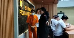 Tersangka pemerasan disertai ancaman penyebaran konten seksual alias Video Call Sex (VCS) saat digiring petugas di Mapolda Metro Jaya, Jakarta Selatan, Selasa, 6 Mei 2025. (Sumber: Poskota/Ali Mansur)