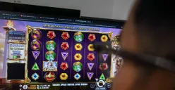 Seorang warga bermain judi online di kawasan perkantoran Palmerah, Jakarta Barat, Jum'at, 9 Mei 2025. PPATK mencatat transaksi judi online di Jakarta menjadi salah satu yang tertinggi di seluruh Indonesia. (Sumber: Poskota/Bilal Nugraha Ginanjar)