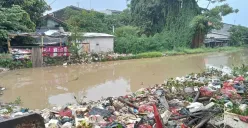 Air kali di Jalan, Teluk Pucung, Bekasi Utara, Kabupaten Bekasi meluap seusai diterjang hujan deras sejak pagi hari, Sabtu, 10 Mei 2025. (Sumber: Poskota/Nurpini Aulia Rapika)