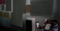 Seorang warga bermain judi online di kawasan perkantoran Palmerah, Jakarta Barat, Jum'at, 9 Mei 2025. PPATK mencatat transaksi judi online di Jakarta menjadi salah satu yang tertinggi di Indonesia. (Sumber: Poskota/Bilal Nugraha Ginanjar)
