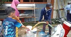 Warga Perumahan Panjibuwono, Kecamatan Babelan, Kabupaten Bekasi, mengantre untuk mendapatkan air bersih gratis dari PDAM Tirta Bhagasasi, Rabu, 14 Mei 2025. (Sumber: Poskota/Nurpini Aulia Rapika)