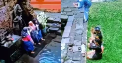 Aksi para Ibu-Ibu yang asyik berfoto di depan arca Candi Belahan Pasuruan saat ada orang yang sedang melakukan sembahyang.