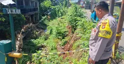 Petugas kepolisian menunjukan tebing longsor di Jalan Raya Krukut RT 04/RW 01, Kelurahan Krukut. Kecamatan Limo, Kota Depok, Selasa, 4 November 2025. (Sumber: Poskota/Angga Pahlevi)