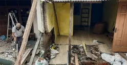 Warga membersihkan puing-puing rumahnya yang hancur akibat pergerakan tanah di Gang Sumur Jambu, Makasar, Jakarta Timur. (Sumber: Poskota/Bilal Nugraha Ginanjar)