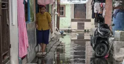 Warga melintasi genangan banjir rob di Muara Angke, Jakarta Utara, Rabu, 5 November 2025. (Sumber: Poskota/Bilal Nugraha Ginanjar)