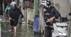 Ilustrasi - Warga melintasi genangan banjir. (Sumber: Poskota/Bilal Nugraha Ginanjar)
