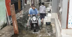 Ilustrasi, warga melintasi genangan banjir rob di Muara Angke, Jakarta Utara, Rabu, 5 November 2025. (Sumber: Poskota/Bilal Nugraha Ginanjar)