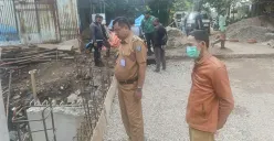 Lurah Krukut Ron Mahendra Jaya bersama petugas kelurahan saat meninjau lokasi pekerjaan jembatan Jalan Rawa Jati. (Sumber: Poskota/Angga Pahlevi)