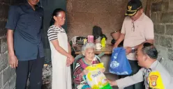 Bhabinkamtibmas Kelurahan Pengasinan, Polsek Bojongsari, memberikan bantuan sembako kepada warga lansia yang tinggal di rumah tidak layak huni di Sawangan, Depok. (Sumber: Poskota/Angga Pahlevi)