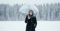 Hadil edit foto wanita berhijab di tengah salju saat musim dingin pakai prompt Gemini AI. (Sumber: Gemini AI)