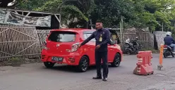 Petugas keamanan kompleks menunjukkan TKP aksi perampokan di Jalan Raya Nonon Sonthanie, Bekasi Timur, Kota Bekasi. (Sumber: POSKOTA | Foto: Nurpini Aulia Rapika)