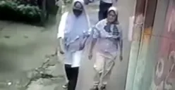 Tangkap layar pelaku hipnotis (bermasker) terekam CCTV berjalan bersama korban di Desa Waru, Kabupaten Bogor.