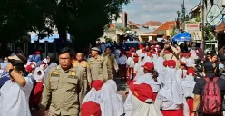 Ribuan pelajar memenuhi Jalan Komodo Raya, Kelurahan Kayuringin Jaya, Kecamatan Bekasi Selatan, Kota Bekasi, untuk menyambut kedatangan Presiden Prabowo Subianto. Senin 17 November 2025. (Sumber: Poskota/Nurpini Aulia Rapika)