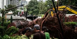 Petugas membersihkan sisa-sisa dari pohon tumbang di atas area transisi antara Stasiun MRT ASEAN dengan Stasiun MRT Mastercard di Jalan Sisingamangaraja, Jakarta Selatan, Kamis, 20 November 2025. (Sumber: POSKOTA | Foto: Bilal Nugraha Ginanjar)