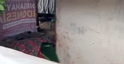 Jasad pria berinisial H tergeletak yang tewas akibat ledakan benda diduga mortir di Kampung Ujung Harapan, Kelurahan Bahagia, Kecamatan Babelan, Kabupaten Bekasi, Minggu, 23 November 2025. (Sumber: POSKOTA | Foto: Nurpini Aulia Rapika)
