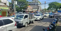 Kemacetan lalu lintas di kawasan permukiman dan pertokoan di Depok, dengan sejumlah mobil dan motor saling berebut ruang di persimpangan jalan. (Sumber: Poskota/Angga Pahlevi)