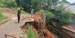 Tim pekerja proyek tanggul mengecek lokasi jalan longsor di Jalan Pelita Ujung RT 06 RW 03, Kelurahan Limo, Kecamatan Limo, Kota Depok, Kamis, 27 November 2025. (Sumber: Poskota/Angga Pahlevi)