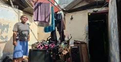 Dodi, 40 tahun, berdiri di area rumahnya yang mengalami kerusakan parah pada bagian atap di Depok. Kondisi rumah tanpa atap membuat para penghuninya terpaksa mengungsi saat turun hujan. (Sumber: Poskota/Angga Pahlevi)