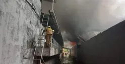 Petugas berusaha memadamkan api saat kebakaran terjadi di gudang aksesoris mobil, Jalan Mangga Ubi RT 06 RW 07, Kecamatan Cengkareng, Jakarta Barat, Kamis, 2 Oktober 2025. (Sumber: POSKOTA | Foto: Pandi Ramedhan)