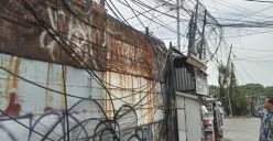 Penampakan kabel semeratut bahkan menjuntai ke bawah di Jalan Raya Kapuk, Penjaringan, Jakarta Utara, Jumat, 3 Oktober 2025. (Sumber: Poskota/Pandi Ramedhan)