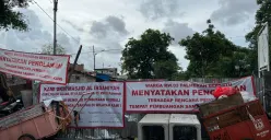 Warga memasang spanduk penolakan pembangunan TPS di RW 03 Palmerah, Jakarta Barat. (Sumber: Poskota/Pandi Ramedhan)
