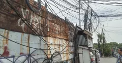 Penampakan kabel semeratut bahkan menjuntai ke bawah di Jalan Raya Kapuk, Penjaringan, Jakarta Utara, Jumat, 3 Oktober 2025. (Sumber: Poskota/Pandi Ramedhan)