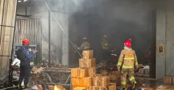 Petugas pemadam melakukan pendinginan di pabrik bingkai yang terbakar pada Selasa pagi 7 Oktober 2025, di Jalan Cikaret, Cibinong, Kabupaten Bogor. (Sumber: Poskota/M. Tegar Jihad)