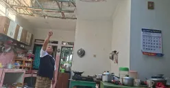 Asep pemilik rumah di Limo, Kota Depok, menunjukan atap rumah yang rusak akibat terkena angin puting beliung. (Sumber: Poskota/Angga Pahlevi)