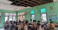 Suasana sejumlah siswa USB SMPN 62 Kota Bekasi mengikuti kegiatan belajar mengajar di ruang kelas dengan atap nyaris roboh, Rabu, 8 Oktober 2025. (Sumber: Poskota/Nurpini Aulia Rapika)
