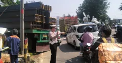 Kanit Lantas Polsek Bojongsari, Iptu Suwardi mengatur lalu lintas di lokasi truk besi anjlok di Jalan Raya Parung-Ciputat, Bojongsari, Kota Depok, Jumat, 10 Oktober 2025. (Sumber: Poskota/Angga Pahlevi)