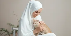 Hasil edit foto prompt Gemini AI terbaru foto wanita berhijab dengan kucing peliharaan di studio. (Sumber: Freepik)