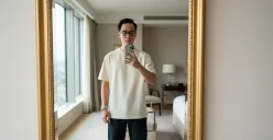 Hasil edi foto prompt Gemini AI terbaru foto cowok pakai iPhone 17 Pro Max sambil mirror selfie di hotel bintang lima. (Sumber: Freepik)