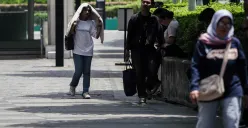 Warga berjalan di tengah cuaca terik di Jalan Jenderal Sudirman, Jakarta, beberapa waktu lalu. (Sumber: Poskota/Bilal Nugraha Ginanjar)