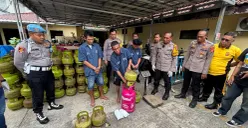 Pelaku mempraktikkan mengoplos gas dari tabung 3 kilogram ke 12 kilogram. (Sumber: Poskota/Giffar Rivana)