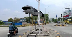 Penampakan patung ikan gabus yang berdiri di depan exit Tol Gabus, Desa Srijaya, Kecamatan Tambun Utara, Kabupaten Bekasi. (Sumber: POSKOTA | Foto: Nurpini Aulia Rapika)