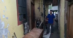 Pemilik kontrakan, H. Mahrub, 63 tahun, menunjukkan kondisi rumah kontrakan di Ciganjur, Jakarta Selatan, yang hangus terbakar setelah disiram bensin oleh mantan pacar penghuni, Jumat, 17 Oktober 2025, subuh. (Sumber: Poskota/Angga Pahlevi)