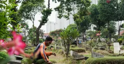 Petugas Suku Dinas Pertamanan dan Hutan Jakarta Selatan membersihkan salah satu makam di Tempat Pemakaman Umum (TPU) Grogol Selatan, Jakarta, Selasa, 21 Oktober 2025. (Sumber: Poskota/Bilal Nugraha Ginanjar)