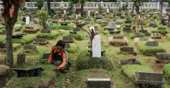 Petugas Suku Dinas Pertamanan dan Hutan Jakarta Selatan membersihkan salah satu makam di Tempat Pemakaman Umum (TPU) Grogol Selatan, Jakarta, Selasa, 21 Oktober 2025. (Sumber: Poskota/Bilal Nugraha Ginanjar)