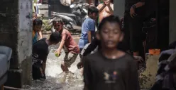 Anak-anak bermain air genangan banjir yang melanda kawasan RT 03, RW 06, Jati Padang, Pasar Minggu Jakarta Selatan, Jumat, 31 Oktober 2025. (Sumber: Poskota/Bilal Nugraha Ginanjar)