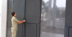 Salah seorang petugas Satpol PP saat memperlihatkan pintu baja di depan Kantor Bupati Pandeglang. (Sumber: Poskota/Samsul Fatoni)