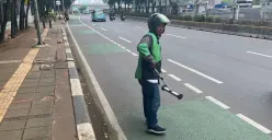 Sopir ojol, Usmanto, 37 tahun, mengambil ranjau paku di Jalan Gatot Subroto, Jakarta Selatan, Senin, 22 September 2025. (Sumber: Poskota/Pandi Ramedhan)